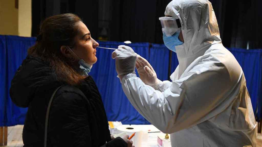 Sanitario realizando una PCR en Cataluña, donde las muertes por Covid-19 han sido hoy más de 100 / EP