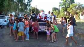 Una foto de archivo de Papá Noel junto a un grupo de niños