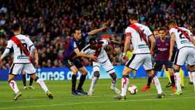 Sergio Busquets intentando robar un balón rodeado de jugadores del Rayo Vallecano / EFE