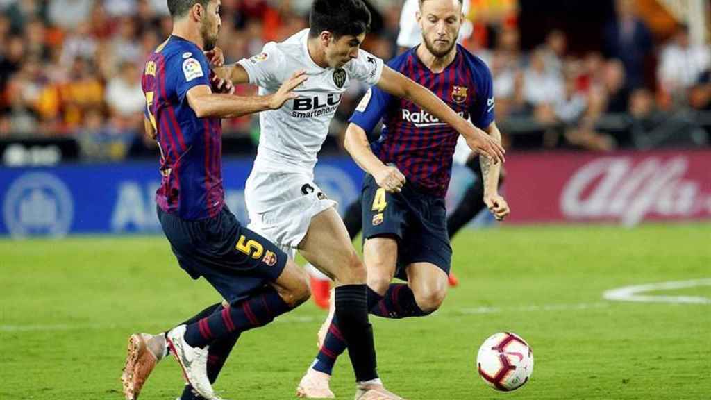 Sergio Busquets y Rakitic disputan un balón con el futbolista del Valencia Carlos Soler / EFE