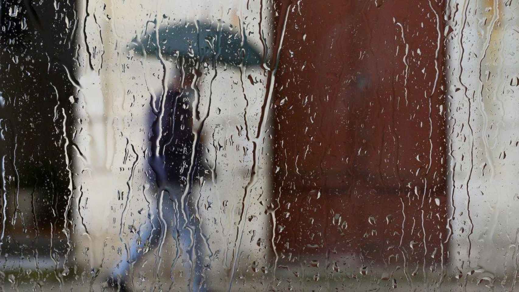 Un hombre camina bajo la lluvia