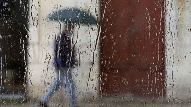 Un hombre camina bajo fuertes lluvias / Pedro Puente Hoyos (EFE)