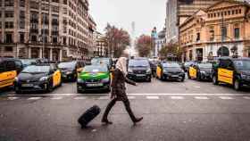 Una ciudadana pasa ante un grupo de taxis durante una protesta en Barcelona / EP