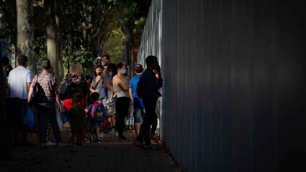 Padres y escolares esperan a las puertas de un colegio / EP