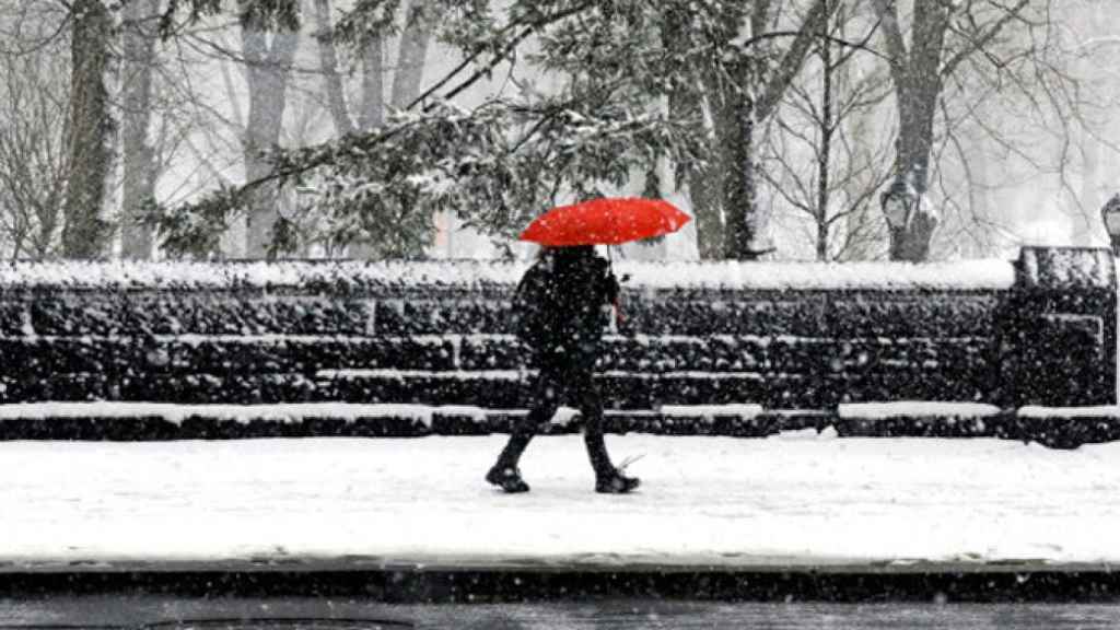 Una mujer pasea bajo la nieve en plena ola de frío / EFE