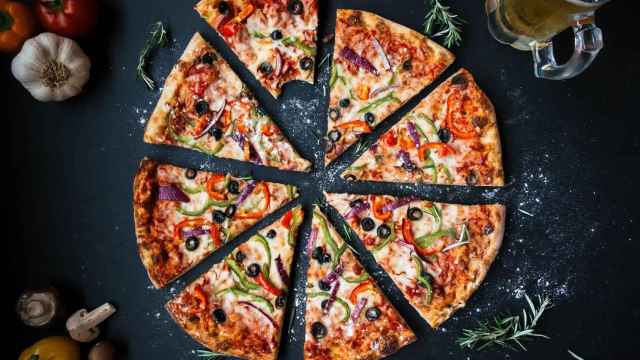 Una pizza rodeada de ingredientes frescos y mediterráneos / PIXABAY