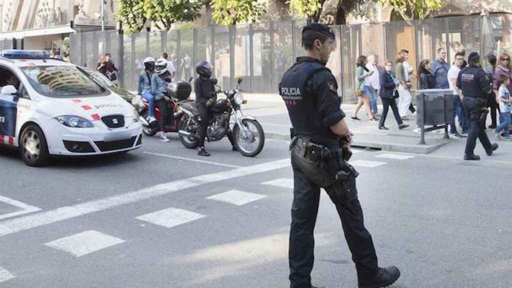 Un agentes de los Mossos d'Esquadra patrulla los alrededores de la Sagrada Familia, el día en el que se ha ordenado que sea la Guardia Civil quien se encargue de coordinar a Mossos, Guardia Civil y Policía para impedir la celebración del referéndum del 1-