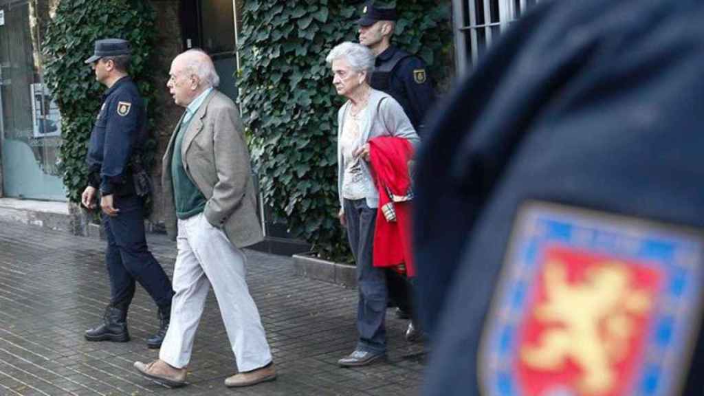 Los Pujol salen de su domicilio mientras la policía lo registra.