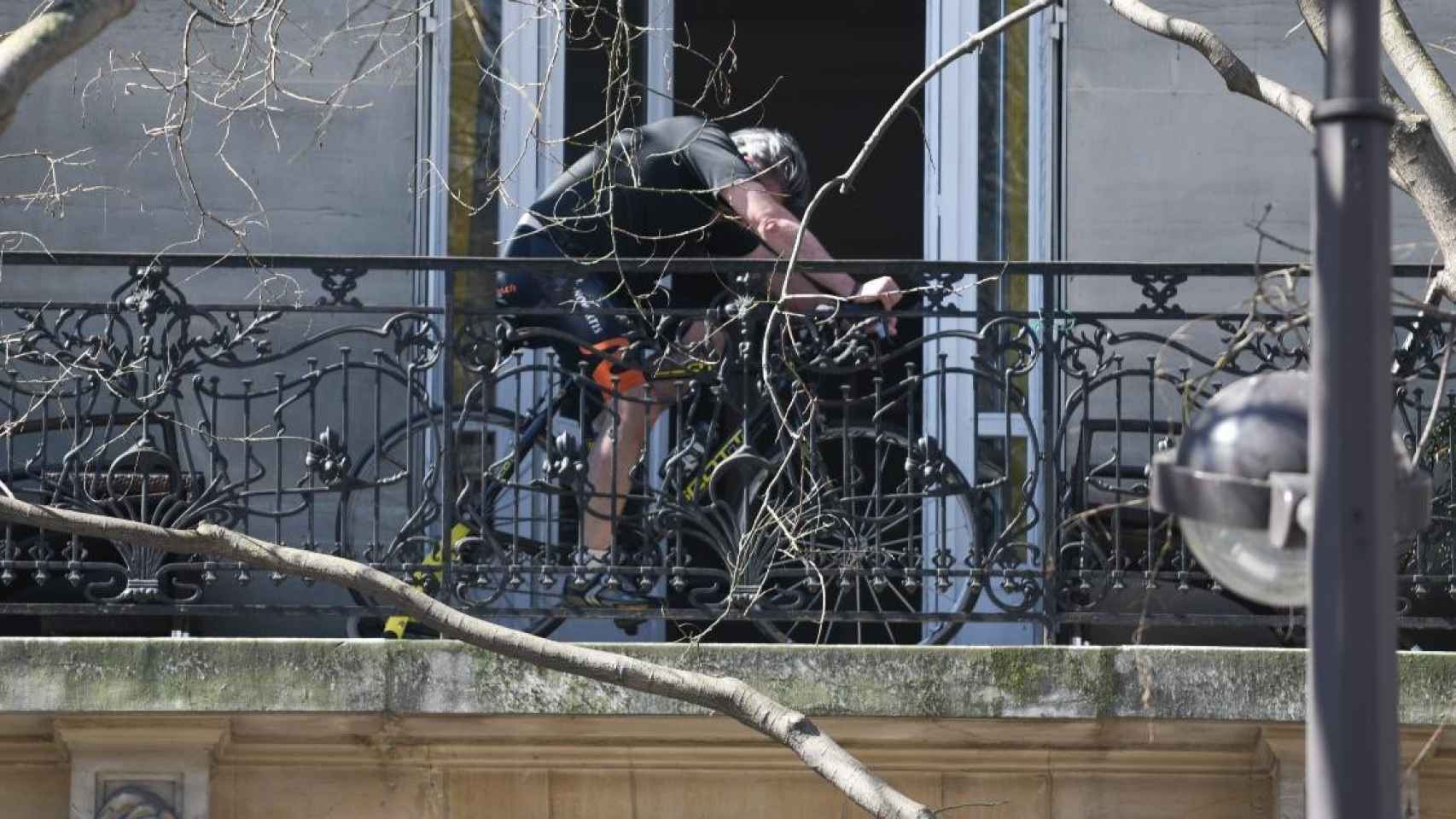 Un hombre con sus bicicletas estáticas pedaleando desde el balcón de su casa / EP