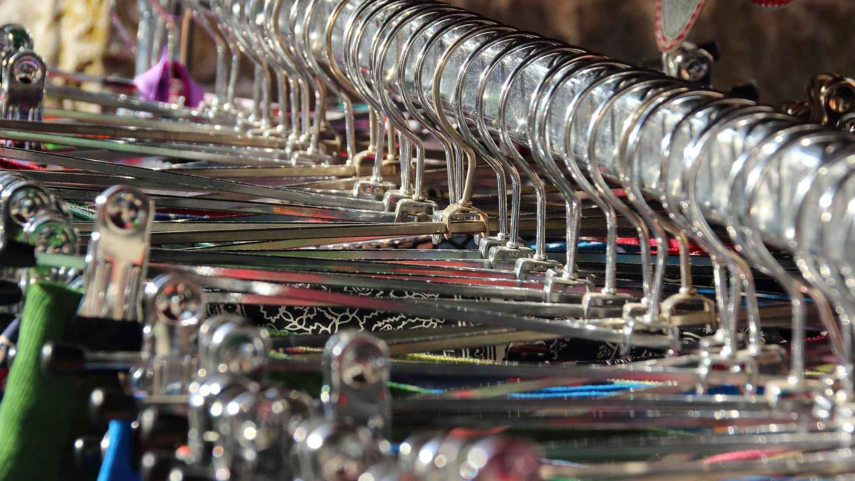 Prendas colgadas en perchas en una tintorería / PIXABAY