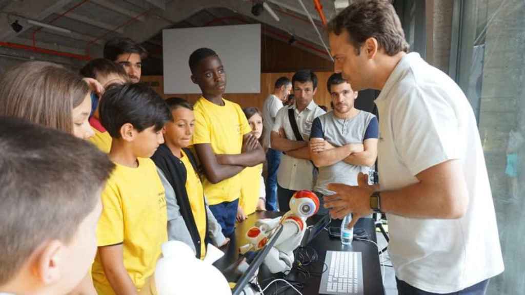 El CEO de Casual Robots, Pablo Medrano, explica a un grupo de niños conocimientos de programación para robots.