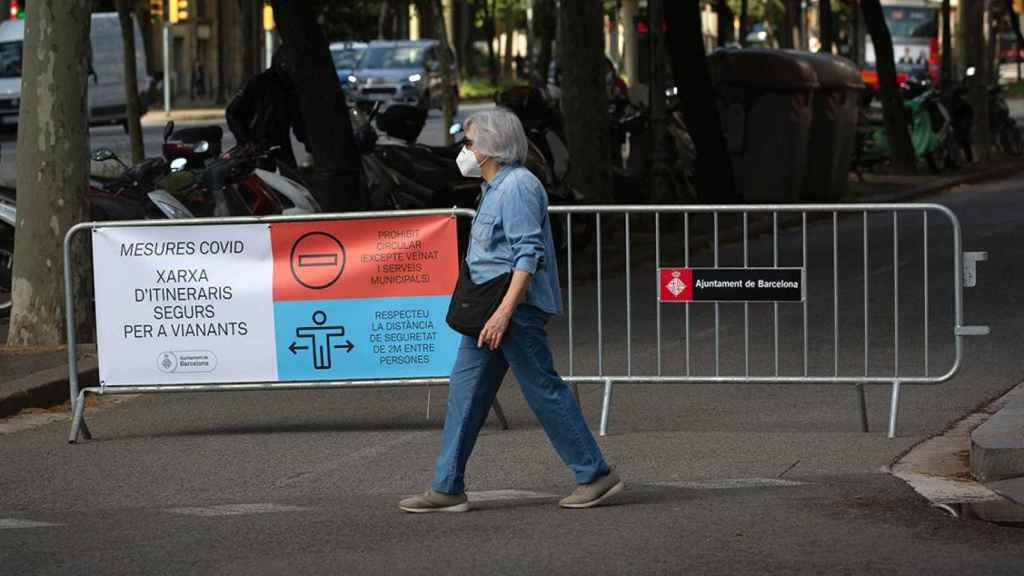 Transeúntes pasan al lado de las vallas instaladas para cortar el tráfico lateral de la Diagonal, en Barcelona / EP