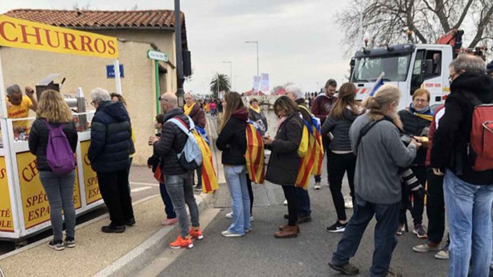 Un vendedor ambulante hace negocio vendiendo churros españoles a los independentistas que asistieron al mitin de Carles Puigdemont en Perpiñán / E-NOTICIES