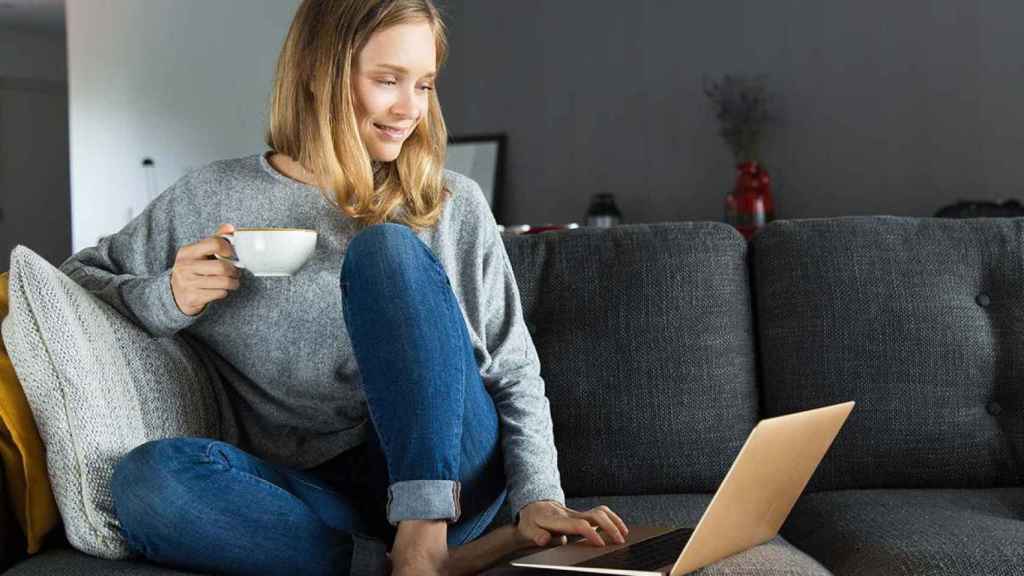 Mujer haciendo compras online desde el sofá