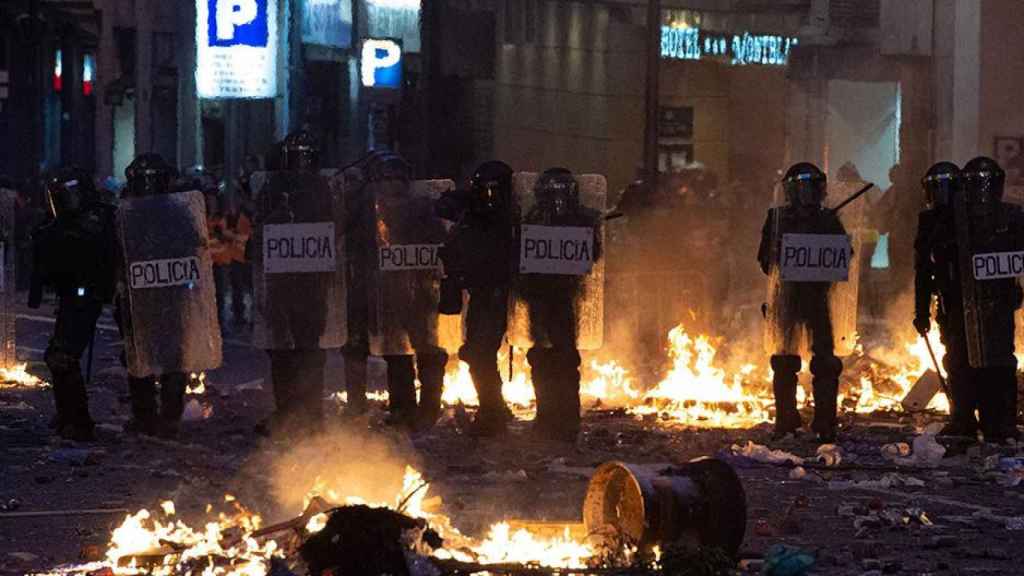 Agentes de la Policía Nacional rodeados de hogueras durante los disturbios en la plaza de Urquinaona, en Barcelona a 18 de octubre de 2019 / EP