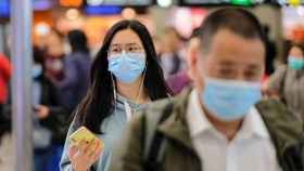 Personas con mascarilla en un aeropuerto de China, que prohíbe los viajes organizados por el coronavirus / EP