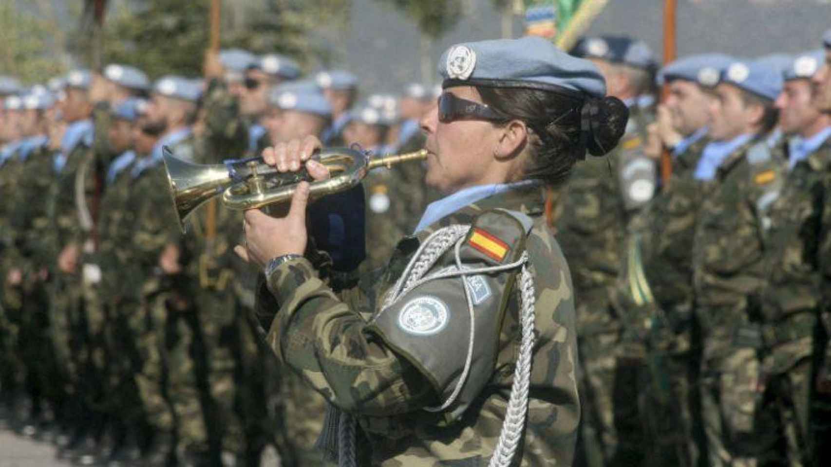 Una soldado da el toque de trompeta frente a una formación militar / EFE