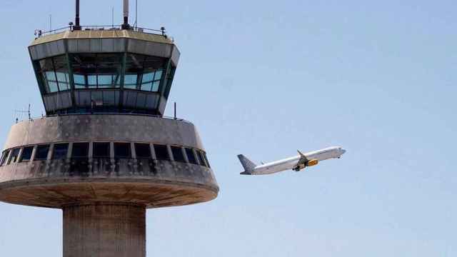 Un avión despega ante la torre de control del aeropuerto Josep Tarradellas Barcelona-El Prat / EFE