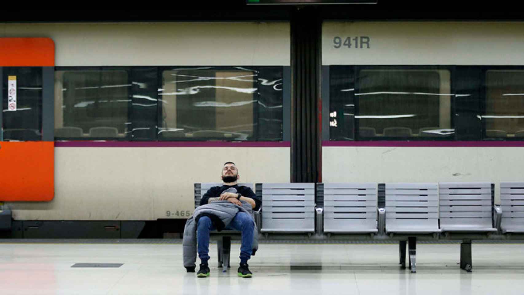 Imagen de un pasajero descansando en un banco de la Estación de Sants de Barcelona / EFE