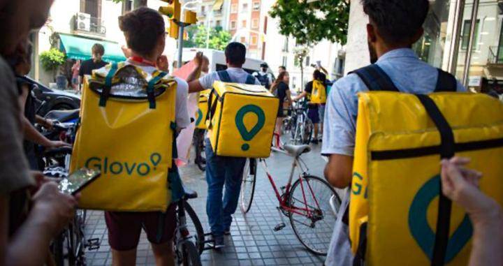 Varios repartidores de Glovo circulan por la acera de una calle de Barcelona / EP