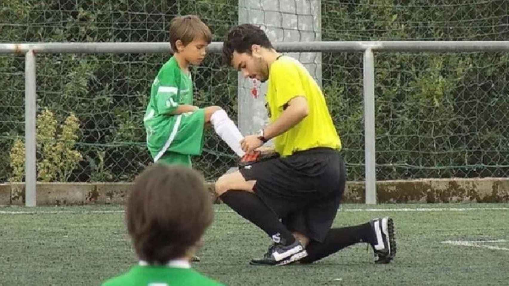 Lucas Vicente ayudando a un niño a atarse los cordones