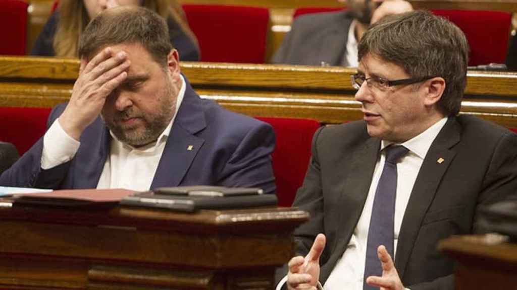 El presidente de la Generalitat, Carles Puigdemont (d) y el vicepresidente económico, Oriol Junqueras (i) en el pleno del Parlament / EFE