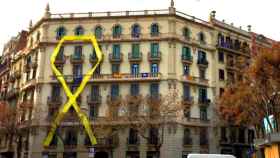 Lazo amarillo en la fachada de un edificio entre la calle Mallorca y Sicilia. Las comunidades de vecinos deben autorizar las banderas / CG
