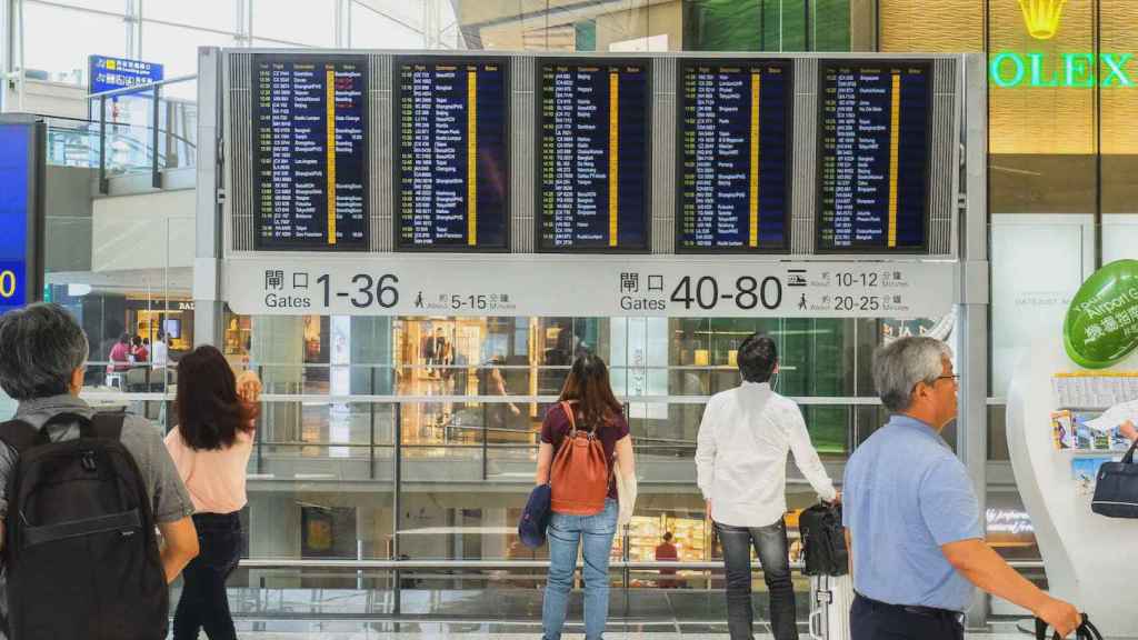 Pasajeros ante un panel informativo de un aeropuerto / PEXELS