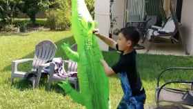 El niño juega con un cocodrilo inflable y detrás de las sillas tiene uno de verdad