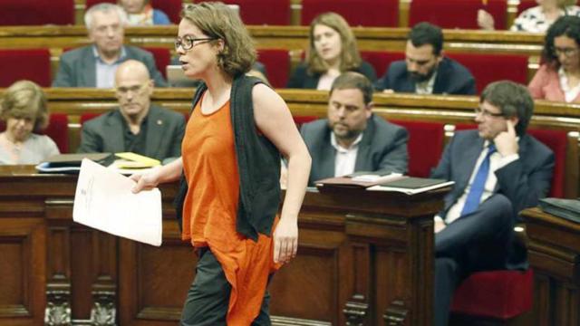 La diputada de la CUP, Eulàlia Reguant, se dirige a la tribuna de oradores del Parlamento catalán, ante la mirada del presidente catalán, Carles Puigdemont, y el vicepresidente, Oriol Junqueras, en una imagen de archivo