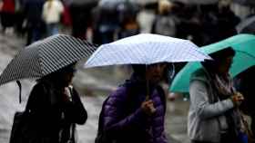 Las fuertes lluvias dejarán imágenes como esta en Cataluña, personas con paraguas / EUROPA PRESS