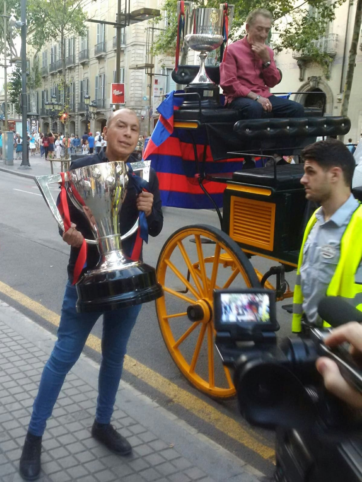 El cofundador de Emblemàtics lleva a Mr. Pinotxo la copa de la Liga y la Copa del Rey del Barça durante un homenaje / CEDIDA