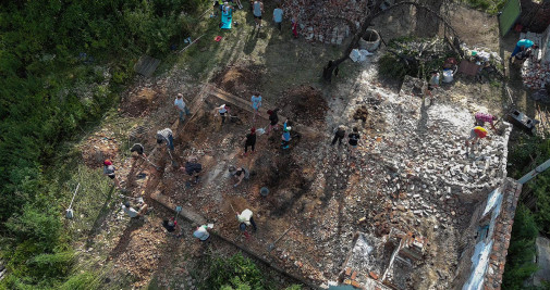 Una imagen tomada con un dron muestra a jóvenes voluntarios de la iniciativa Reparemos juntos junto con residentes locales limpiando escombros de una casa destruida durante la invasión rusa, en la aldea de Ivanivka, región de Chernihiv (Ucrania) - EFE/ Roman Pilipey