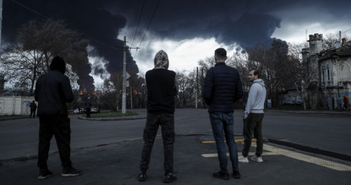 Cuatro hombres observan el ataque ruso a una refinería en Odesa / EFE