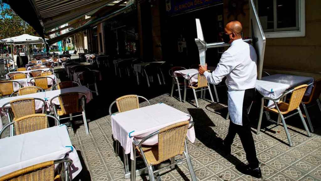 Imagen de un camarero en una terraza vacía. / EFE