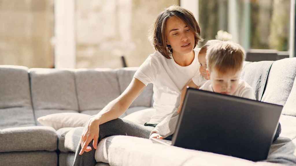 Una madre con sus hijos usan un ordenador / FREEPIK