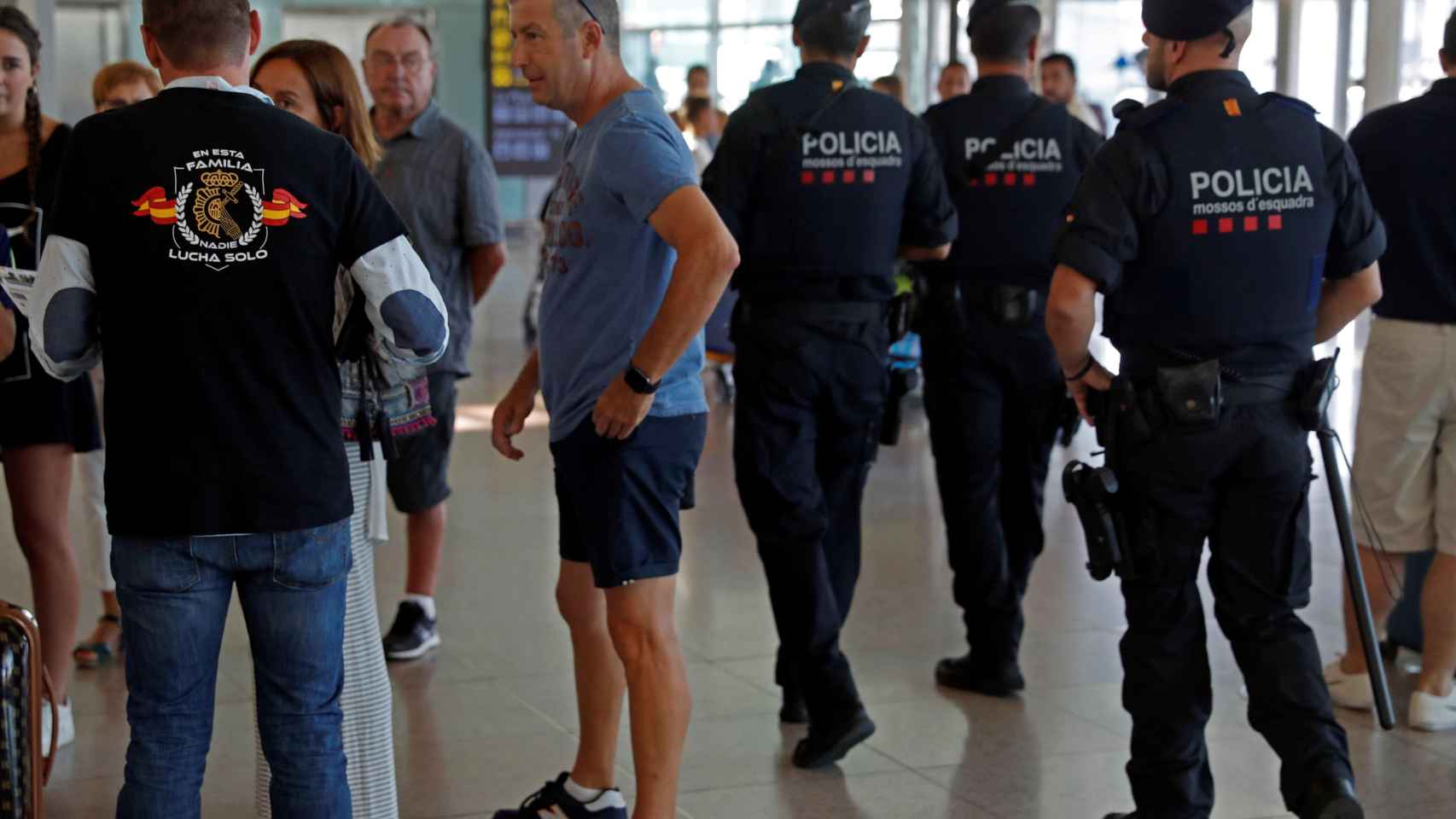 Miembros de Jusapol, de paisano, explican a los turistas que llegan a El Prat que Barcelona es una ciudad segura / EFE