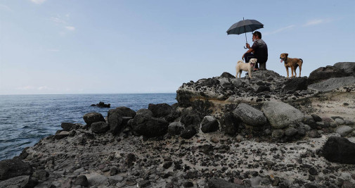 La gente mira hacia el lugar donde se cree que los militares chinos realizan un simulacro de fuego real desde la costa de la ciudad de Nuevo Taipei, Taiwán,este jueves - EFE/ Ritchie B. Tongo