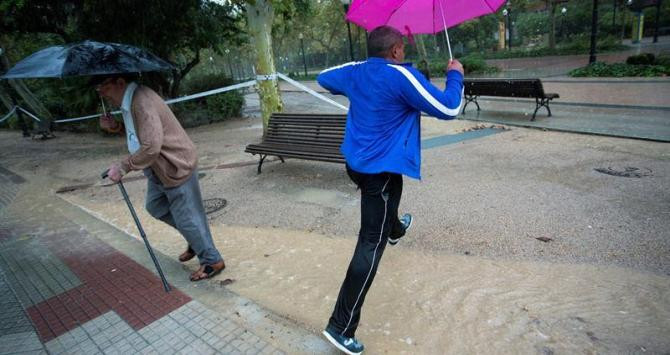 Dos ciudadanos tratan de sortear la lluvia ayer en Castellón / EFE