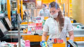 Una dependienta protegida contra el coronavirus en su puesto de trabajo / EFE