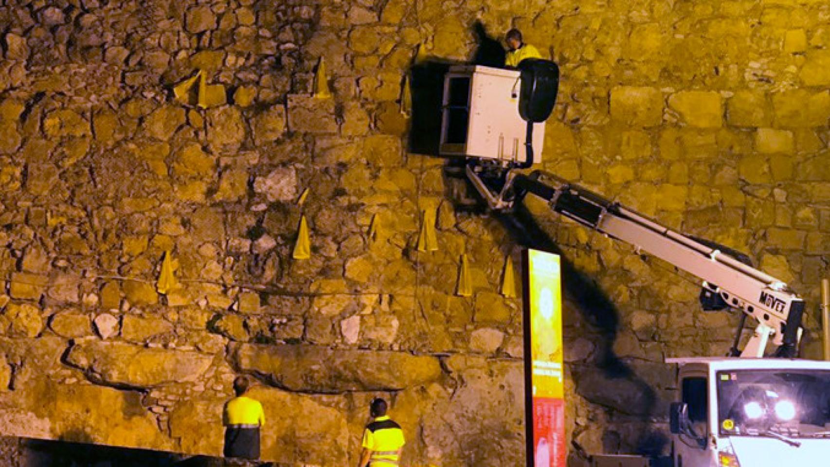 Los operarios del Ayuntamiento de Tarragona retiran los lazos amarillos de la muralla de la ciudad / TWITTER