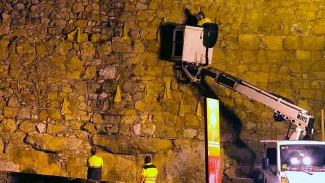 Los operarios del Ayuntamiento de Tarragona retiran los lazos amarillos de la muralla de la ciudad / TWITTER