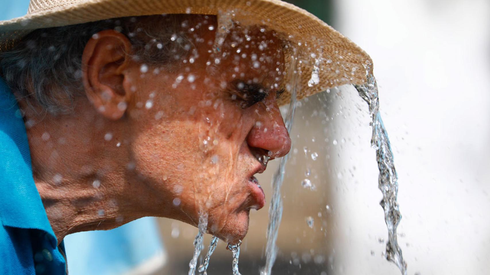 Imagen de un hombre refrescándose en Córdoba / EFE