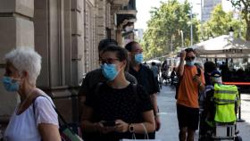 Varias personas hacen cola para entrar en una tienda protegidas con mascarilla / EP
