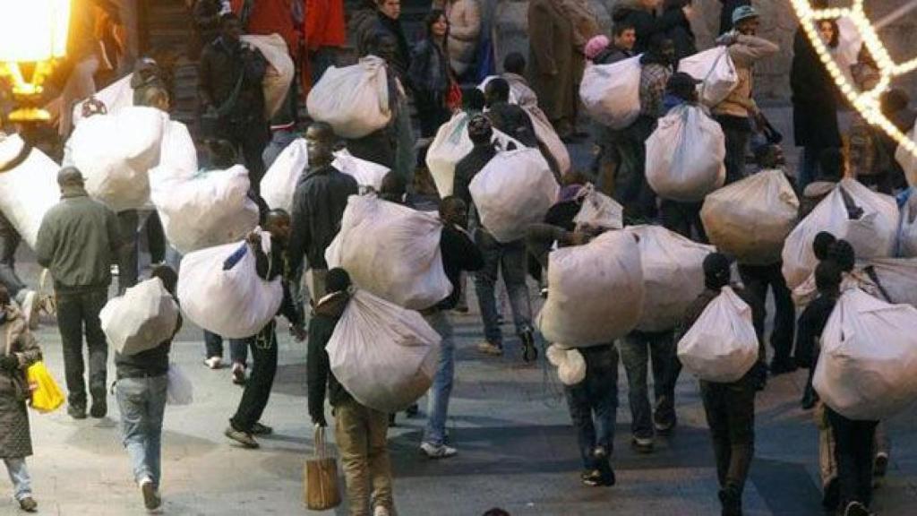 Un grupo de manteros, transportando material de venta en el centro de Barcelona / EFE