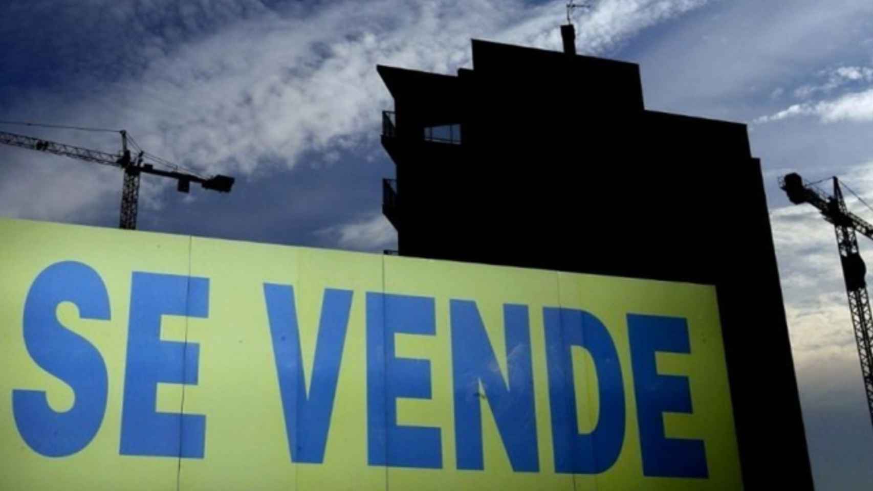 Un bloque de pisos en construcción con un cartel de 'Se vende' / EFE