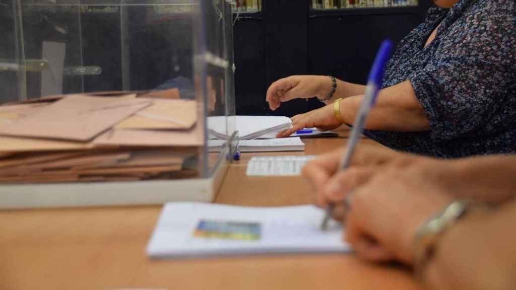 Dos personas atienden una mesa electoral / EP