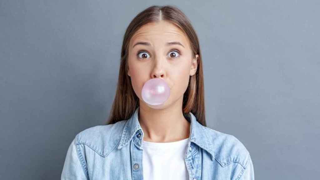 Una foto de una joven mascando chicle, uno de los nueve hábitos