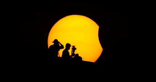 La luna cubre parcialmente el sol durante el eclipse solar de este martes en Marina Beach, Chennai, India / IDREES MOHAMMED – EFE