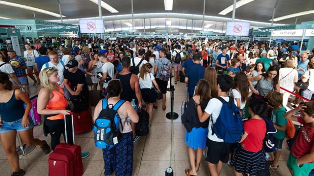 Esperas en los arcos de seguridad del aeropuerto de El Prat el viernes por la tarde / EFE